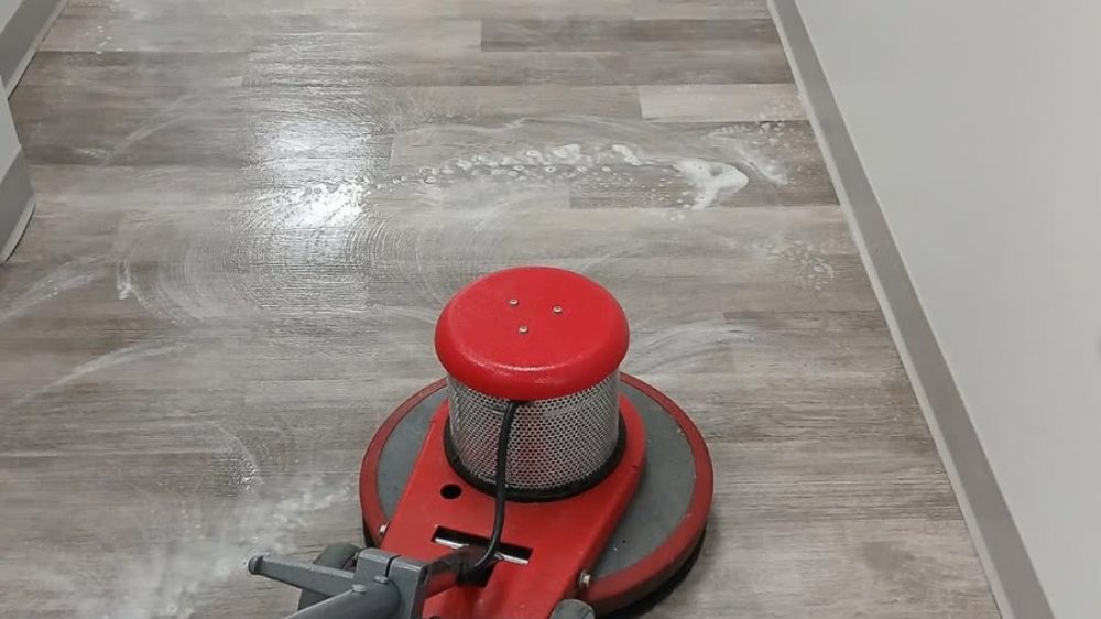 Zimick red floor buffer polishing a commercial LVT hallway