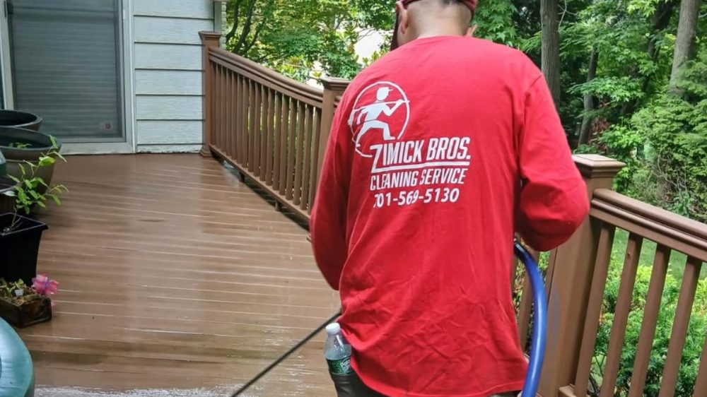 Zimick Brothers crew pressure-washing a wood deck